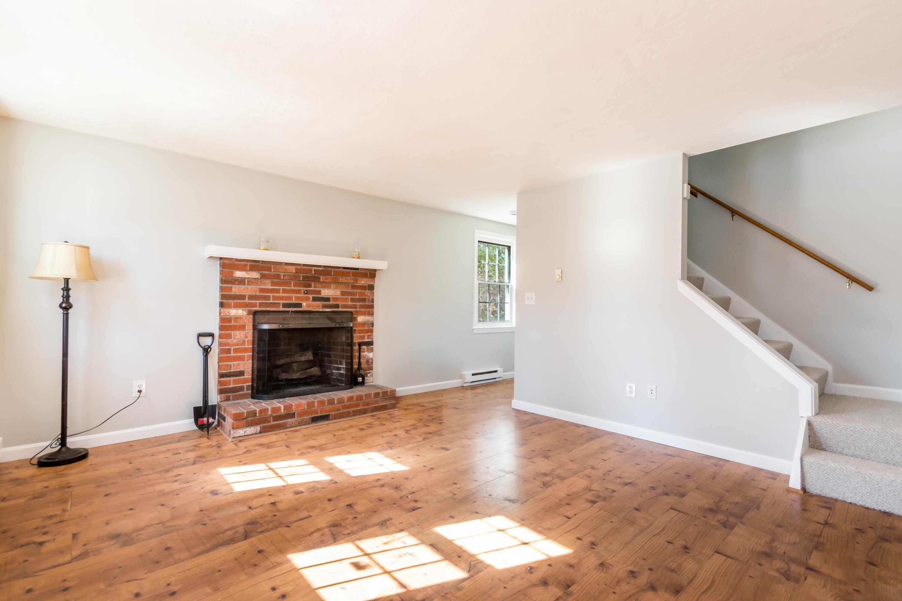 300 Falmouth Road, Unit 16A Mashpee, MA 02649 - Photo 6 of 25 a view of empty room with fireplace and wooden floor