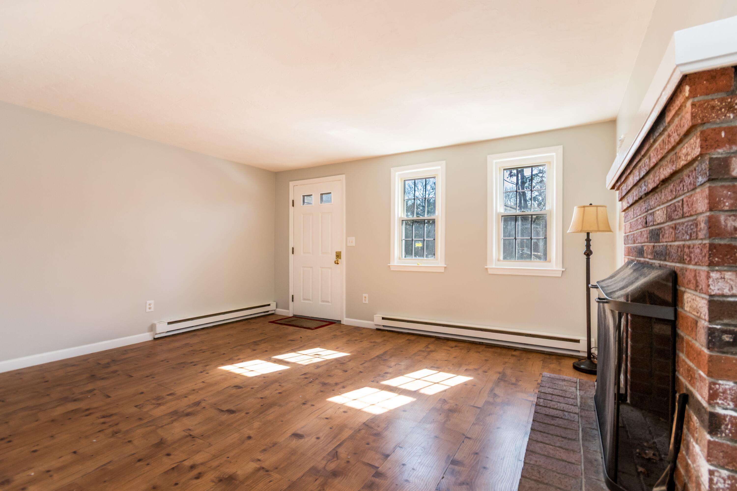 300 Falmouth Road, Unit 16A Mashpee, MA 02649 - Photo 7 of 25 an empty room with wooden floor and windows