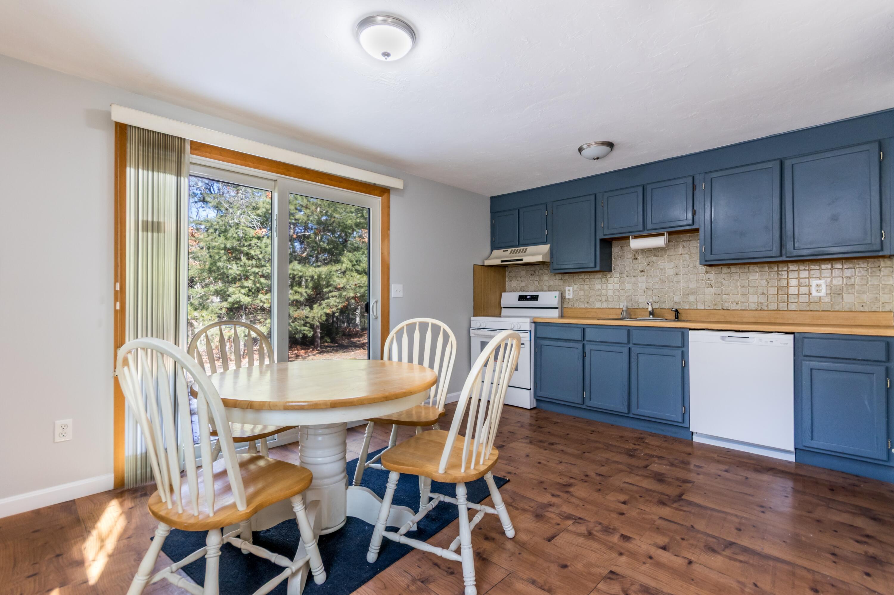 300 Falmouth Road, Unit 16A Mashpee, MA 02649 - Photo 9 of 25 a kitchen with granite countertop wooden floors and wooden cabinets