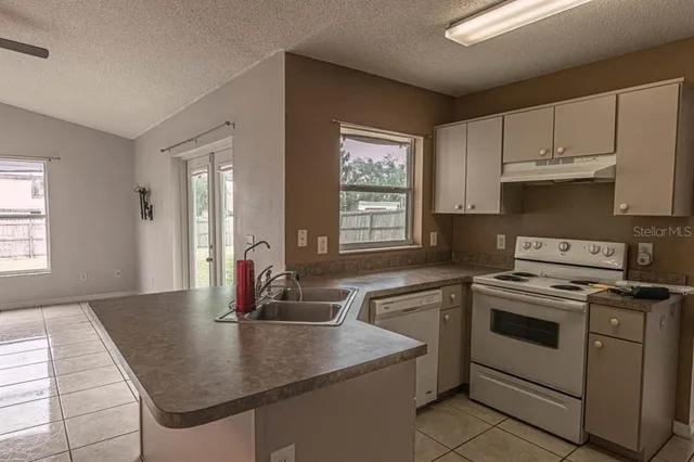 a kitchen with cabinets appliances a sink and a window