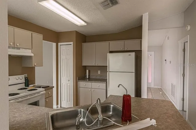 a kitchen with stainless steel appliances granite countertop a refrigerator and a stove top oven