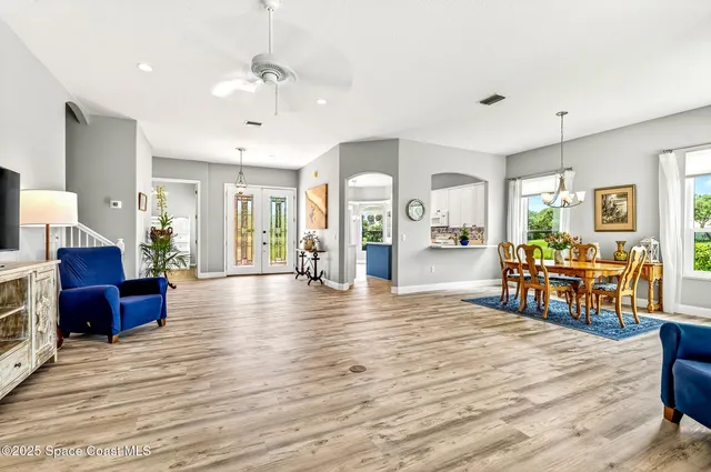 a kitchen with stainless steel appliances granite countertop a stove a refrigerator a sink and white cabinets with wooden floor