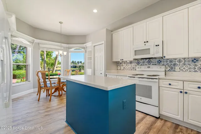 a kitchen with white cabinets appliances and sink