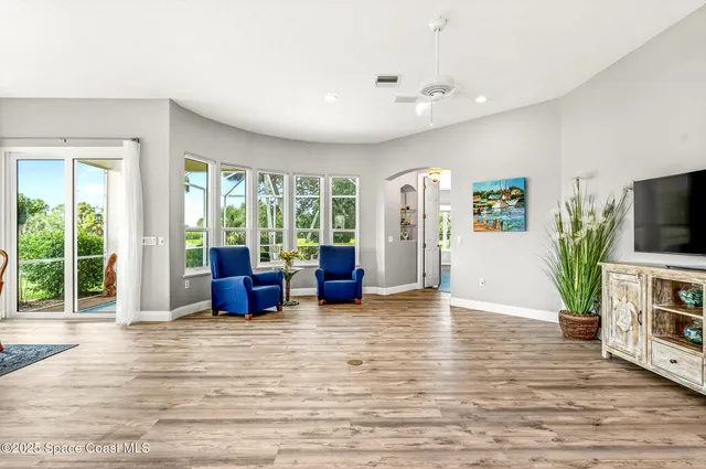 a view of a swimming pool with a patio and wooden chairs