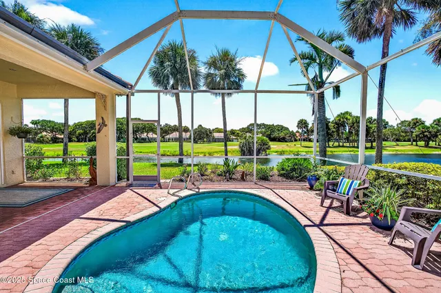 a view of a house with a swimming pool and sitting area