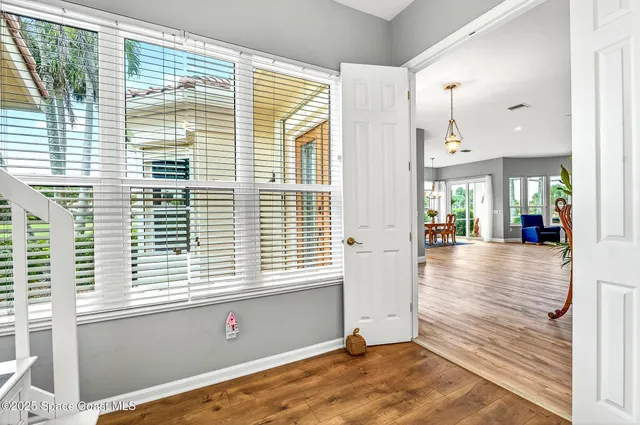 a view of a hallway with wooden floor and staircase