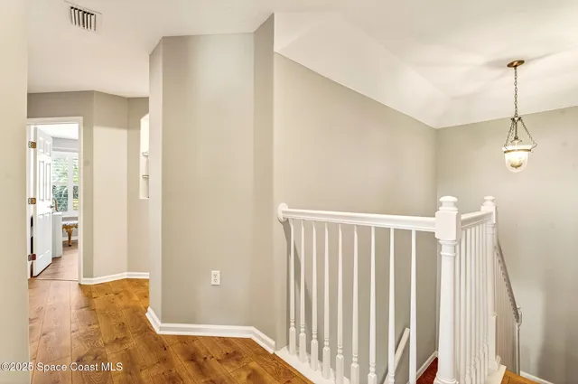 a bedroom with a bed wooden floor and window