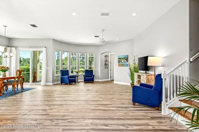 a dining room with furniture potted plants and wooden floor