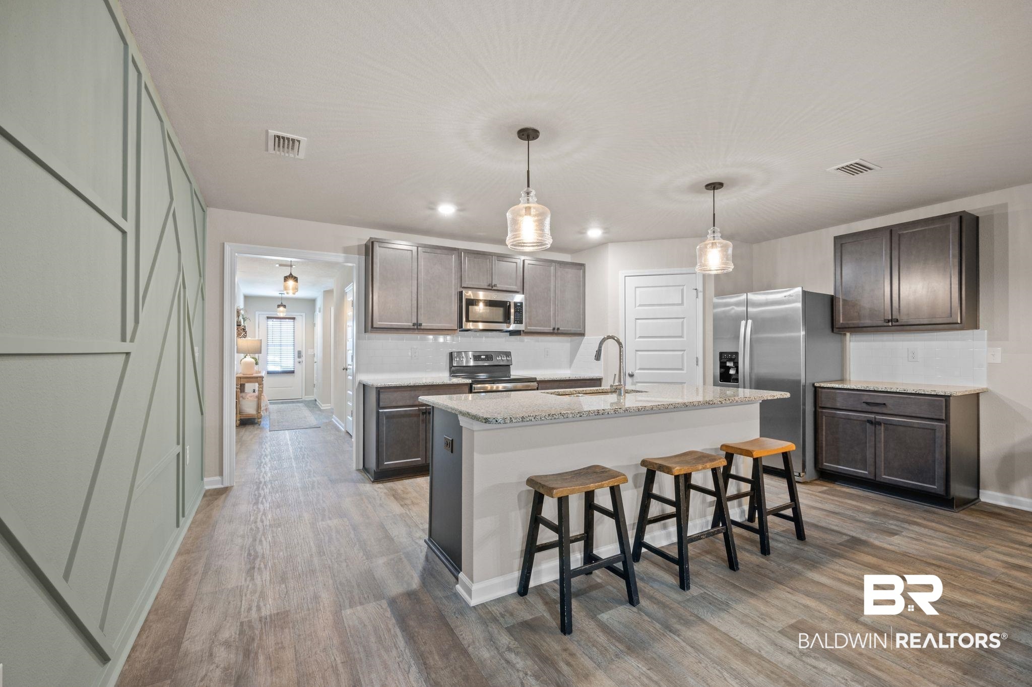 10306 Brodick Loop Spanish Fort, AL 36527 - Photo 11 of 35 Kitchen with appliances with stainless steel finishes, sink, decorative light fixtures, hardwood / wood-style flooring, and an island with sink