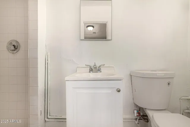 a bathroom with a toilet a sink and mirror