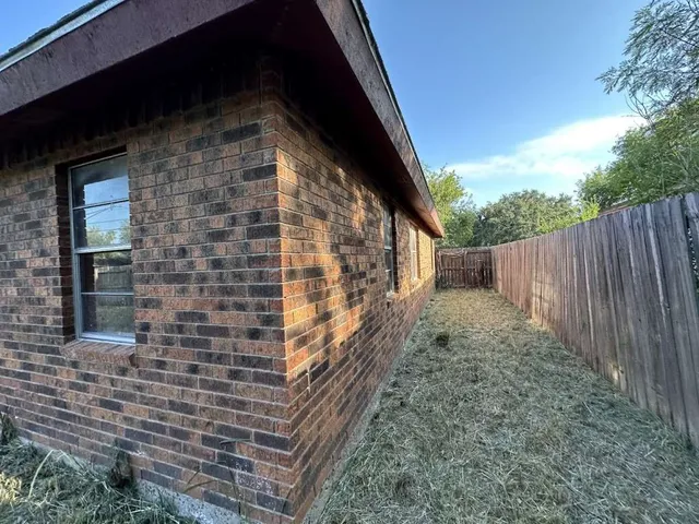 a view of backyard with wooden fence