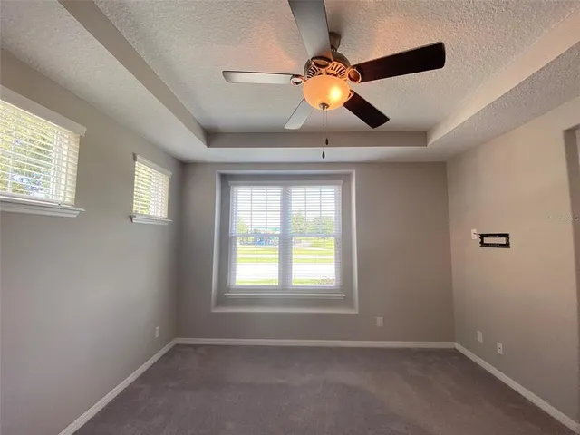 a bedroom with a bed and a chandelier fan