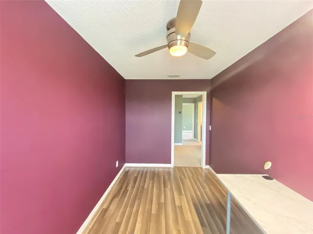 an empty room with a window and a ceiling fan