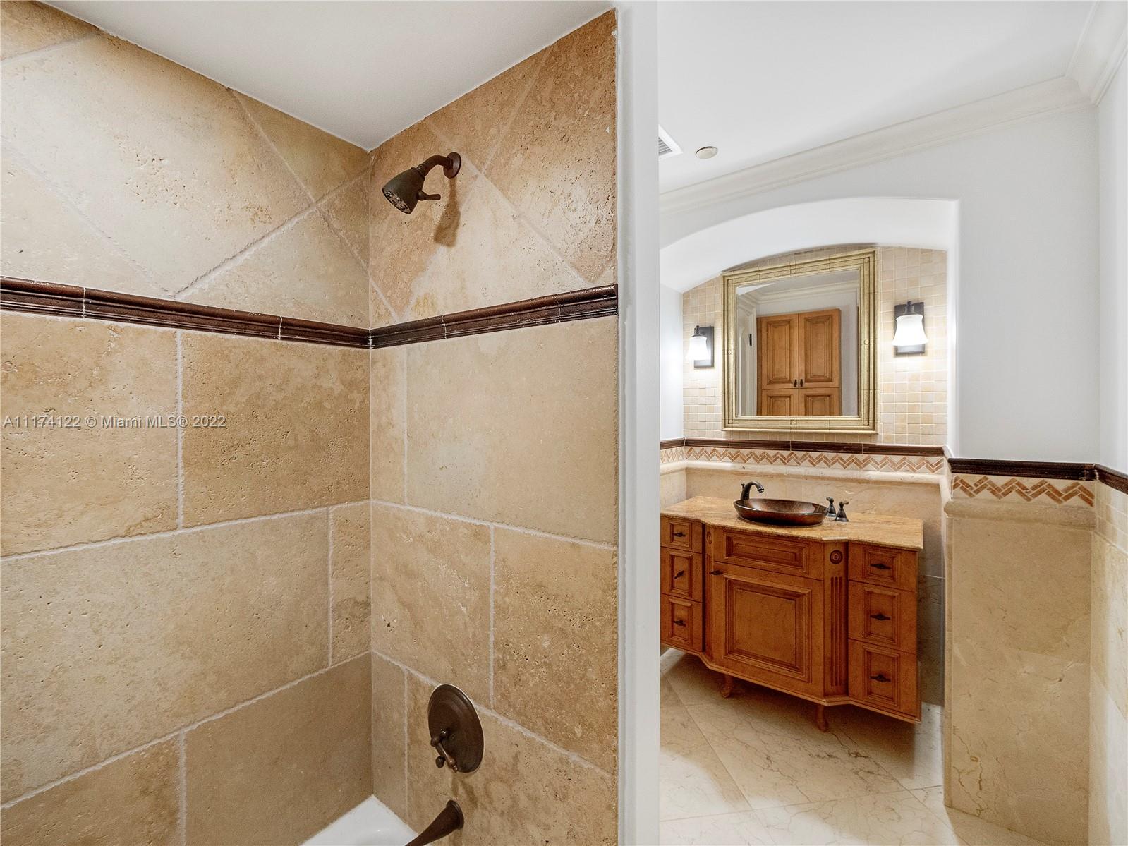 2050 Florida A1A, Unit 2 Jupiter, FL 33477 - Photo 17 of 22 a bathroom with a granite countertop sink a mirror and a shower