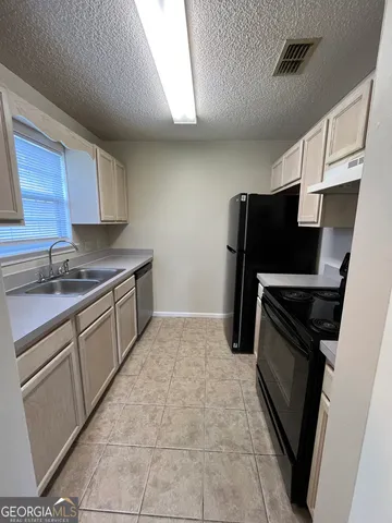 a kitchen with a refrigerator stove and cabinets