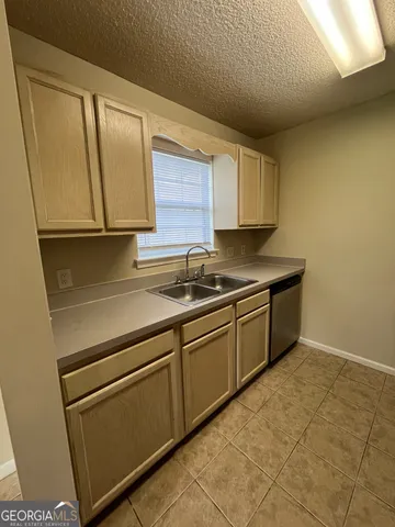 a kitchen with granite countertop cabinets stainless steel appliances and a sink