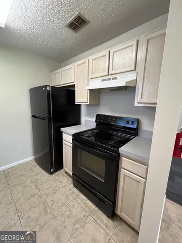 a kitchen with stainless steel appliances a refrigerator a stove a microwave and cabinets