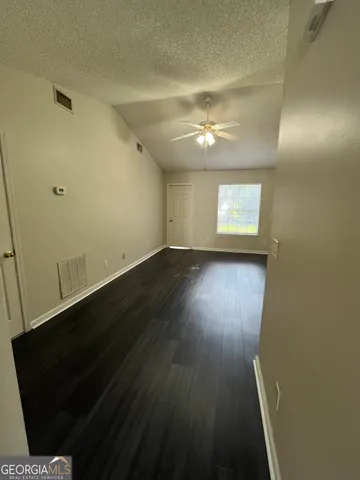 en empty room with wooden floor and windows