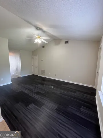 a view of room with wooden floor and ceiling fan