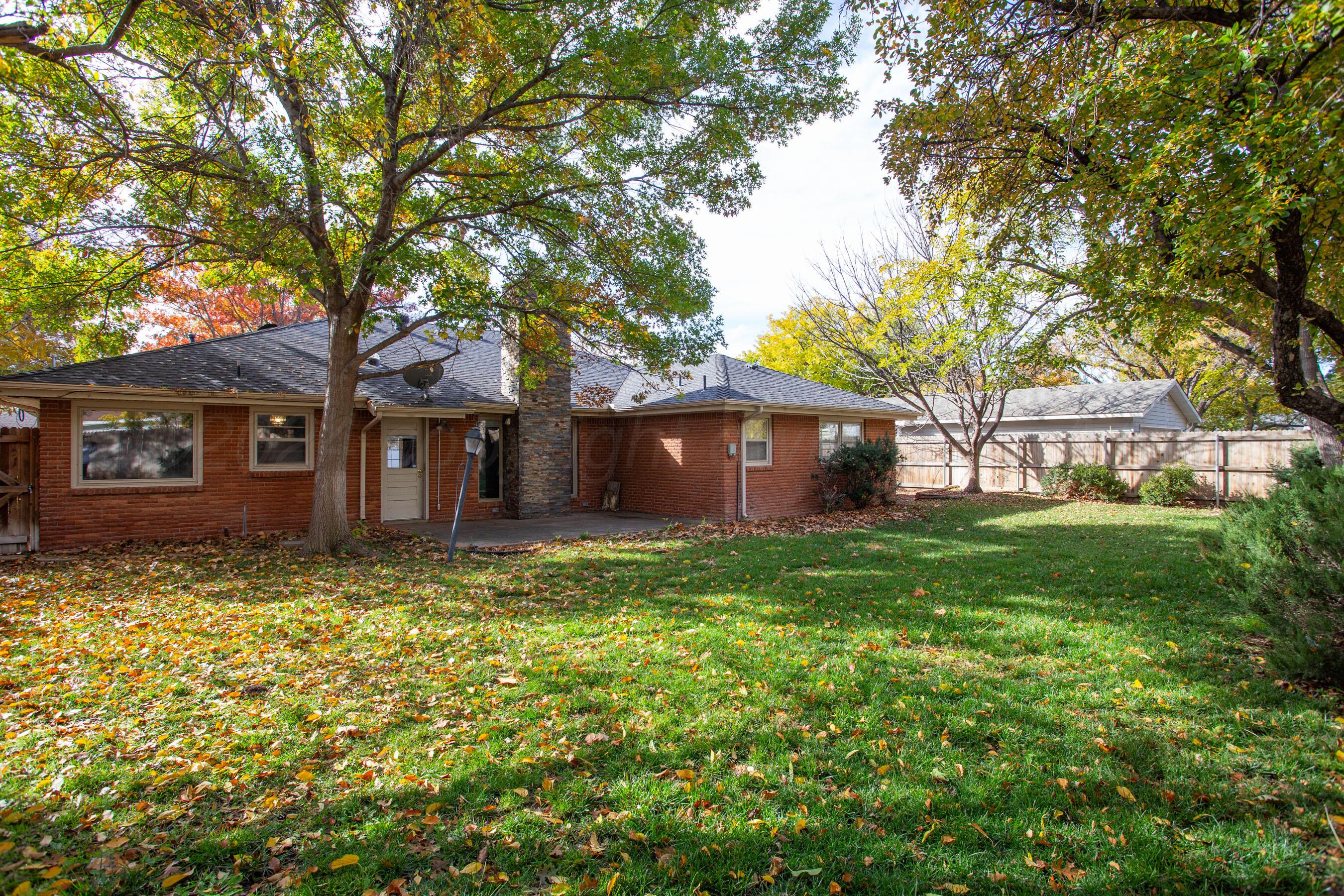 6800 Dreyfuss Road Amarillo, TX 79106 - Photo 31 of 32 a tree in front of a brick house with a large tree