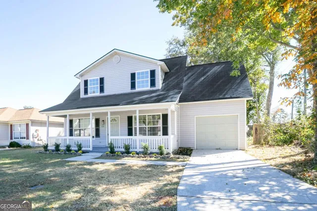 a view of a yard in front of a brick house with large windows