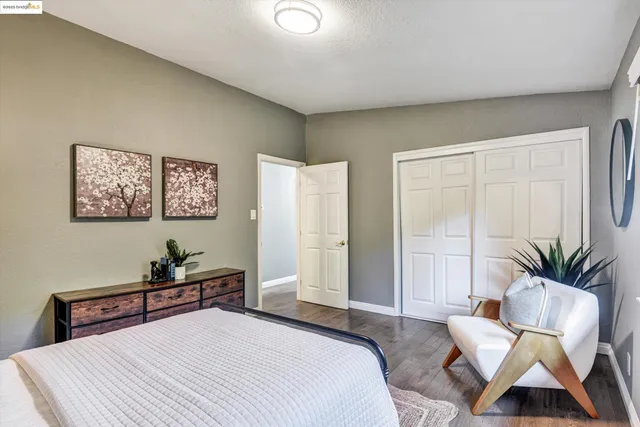 a bedroom with a bed a couch and a potted plant