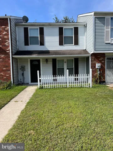 a front view of a house with a garden and plants