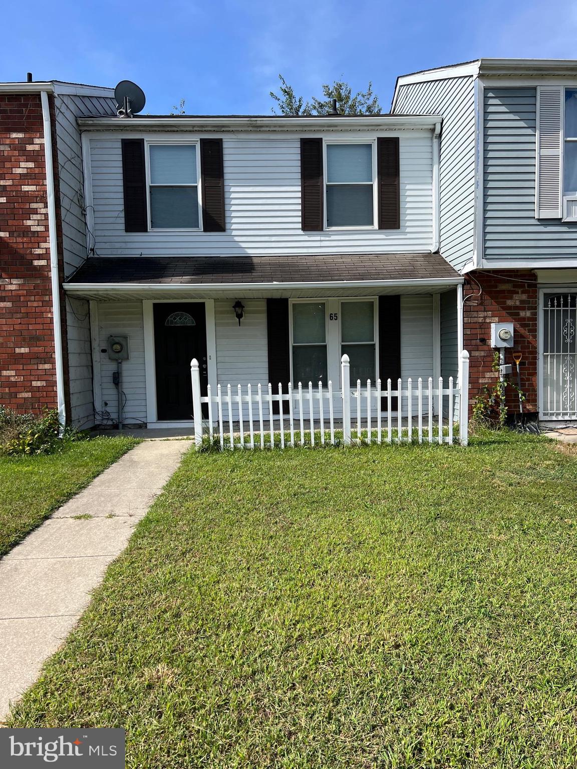 a front view of a house with a garden and plants