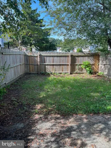 a view of a backyard with a trees and wooden fence