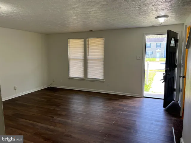 an empty room with wooden floor and a window