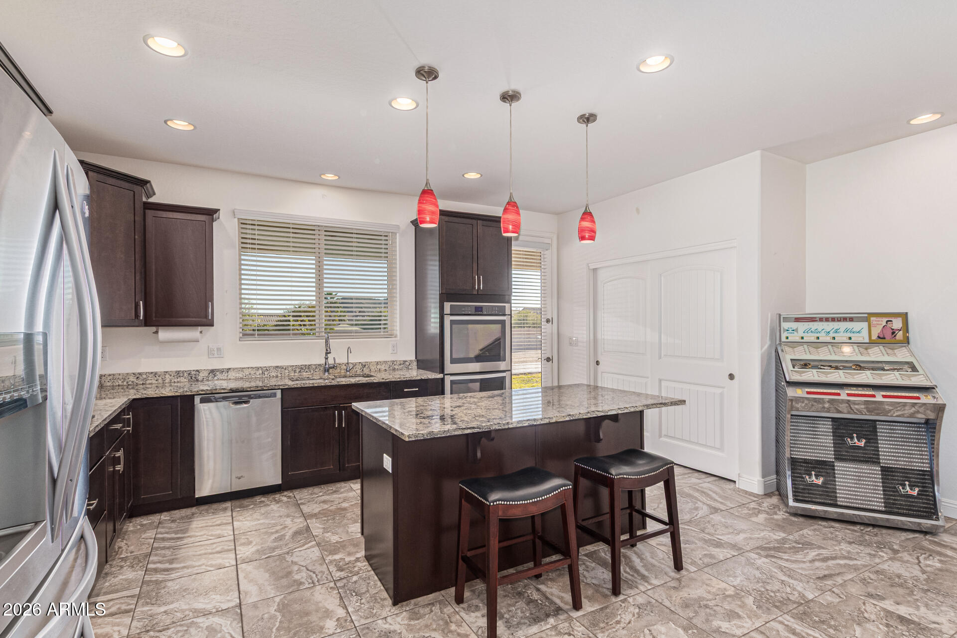 32187 North Royce Road San Tan Valley, AZ 85144 - Photo 8 of 38 a kitchen with kitchen island granite countertop a stove a sink and a refrigerator
