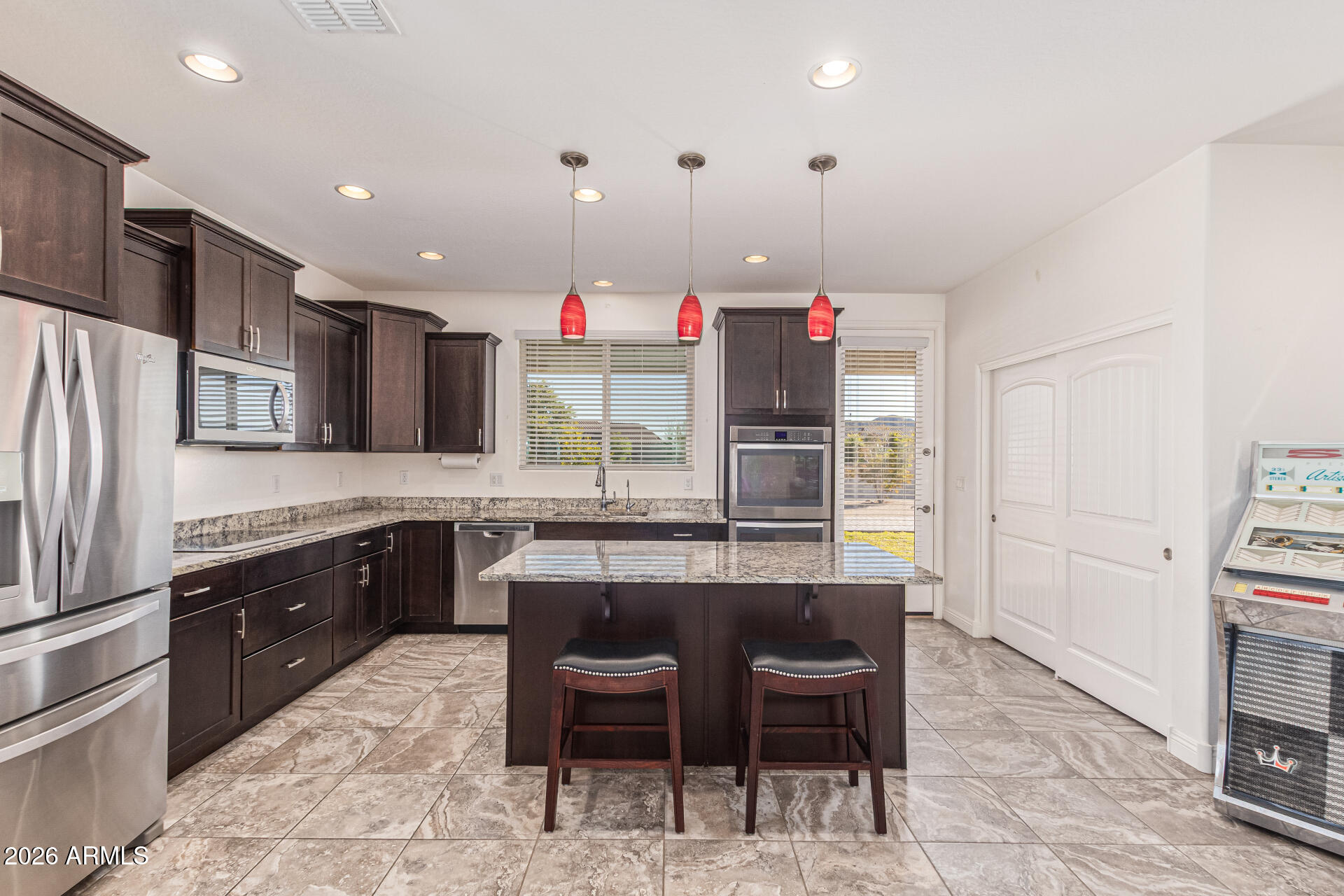 32187 North Royce Road San Tan Valley, AZ 85144 - Photo 9 of 38 a kitchen with kitchen island granite countertop wooden cabinets and stainless steel appliances
