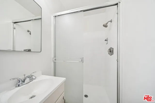 a bathroom with a sink a shower and a mirror