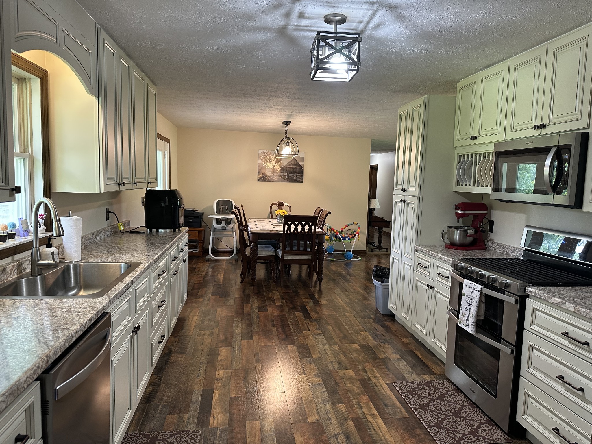 403 Fredonia Road Crossville, TN 38571 - Photo 8 of 50 a kitchen with stainless steel appliances granite countertop a stove top oven a sink a dining table and chairs with wooden floor