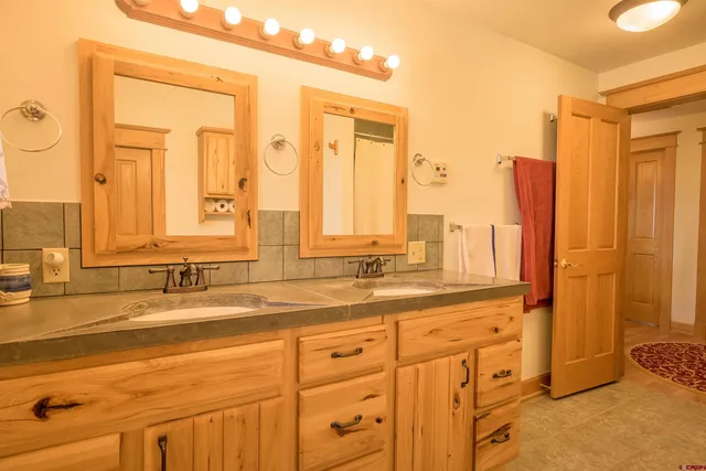 a bathroom with a double vanity sink and a mirror