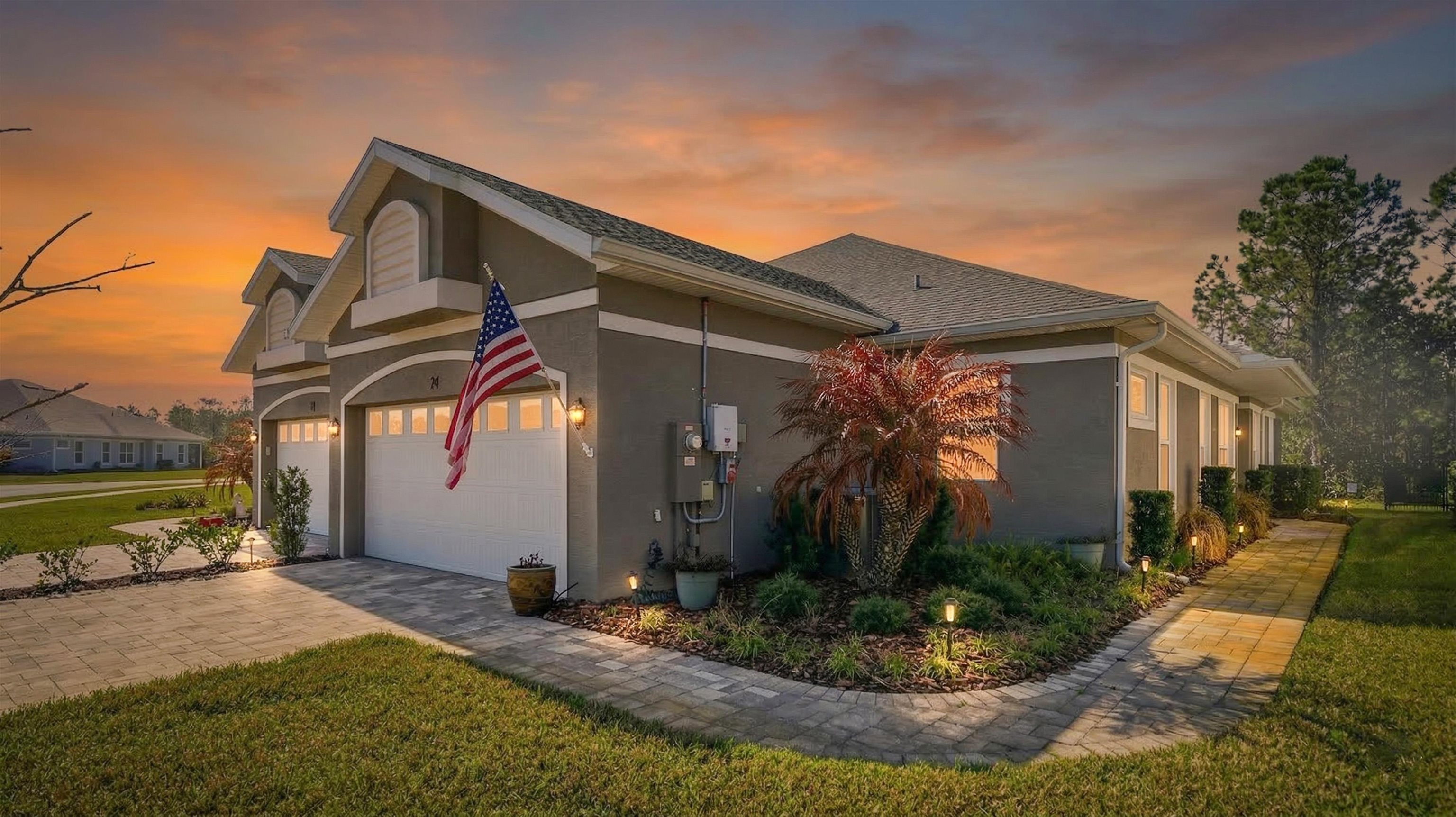 74 Wrendale Loop Ormond Beach, FL 32174 - Photo 14 of 59 Property exterior at dusk with stucco siding, a lawn, and driveway