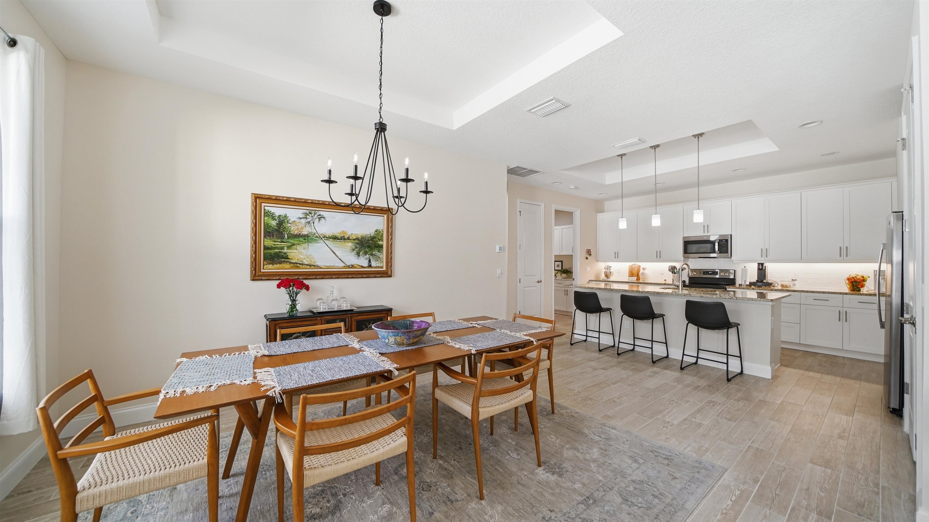 74 Wrendale Loop Ormond Beach, FL 32174 - Photo 18 of 59 Dining room with a tray ceiling, light wood-style flooring, and suspended lighting