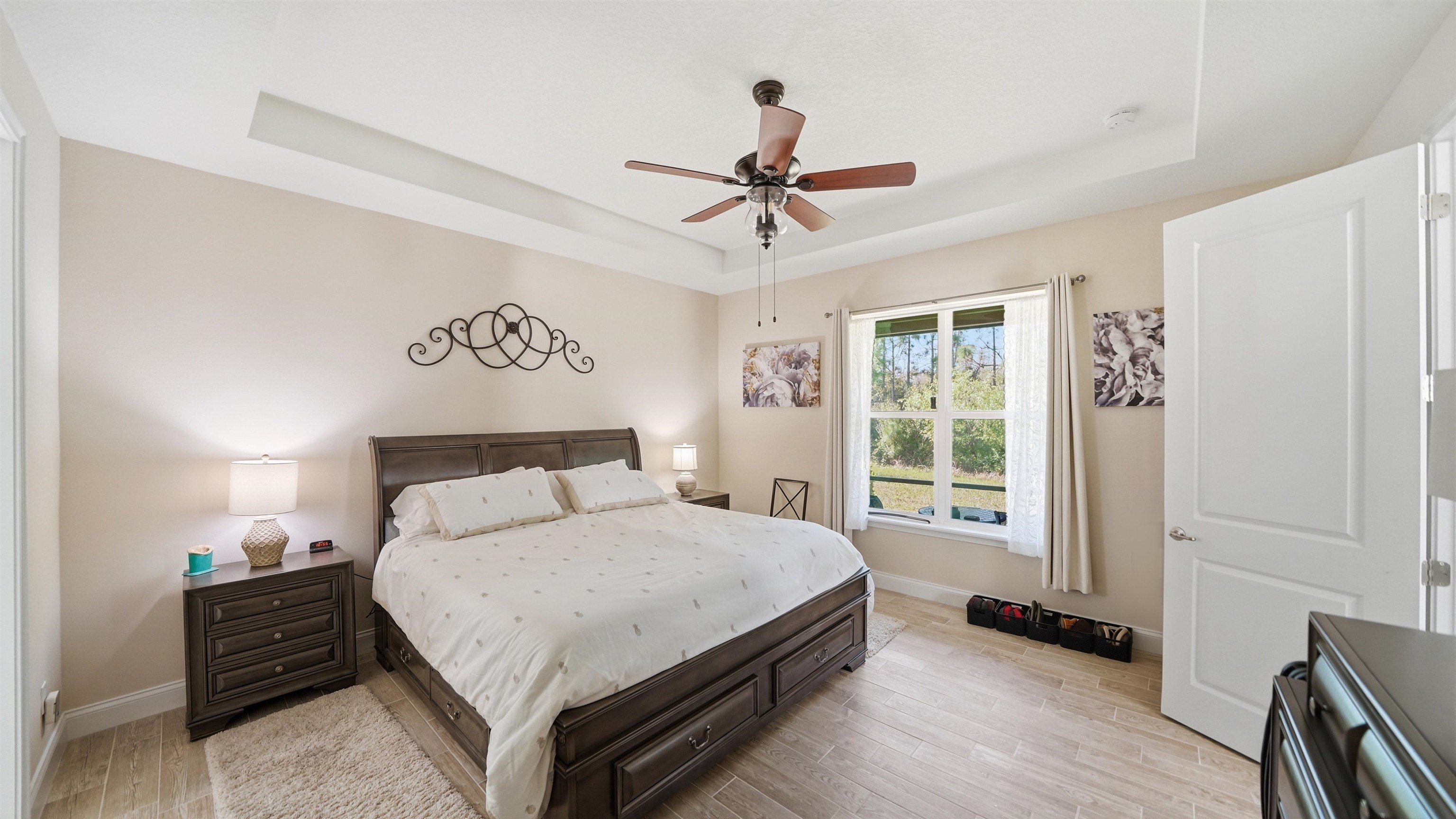 74 Wrendale Loop Ormond Beach, FL 32174 - Photo 23 of 59 Bedroom with light wood-type flooring, a tray ceiling, and ceiling fan