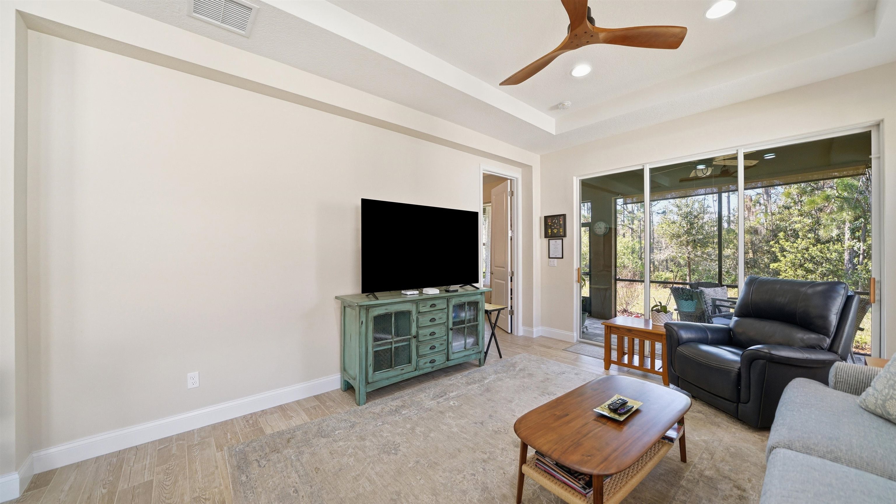 74 Wrendale Loop Ormond Beach, FL 32174 - Photo 24 of 59 Living room featuring a tray ceiling, a ceiling fan, light wood finished floors, and recessed lighting