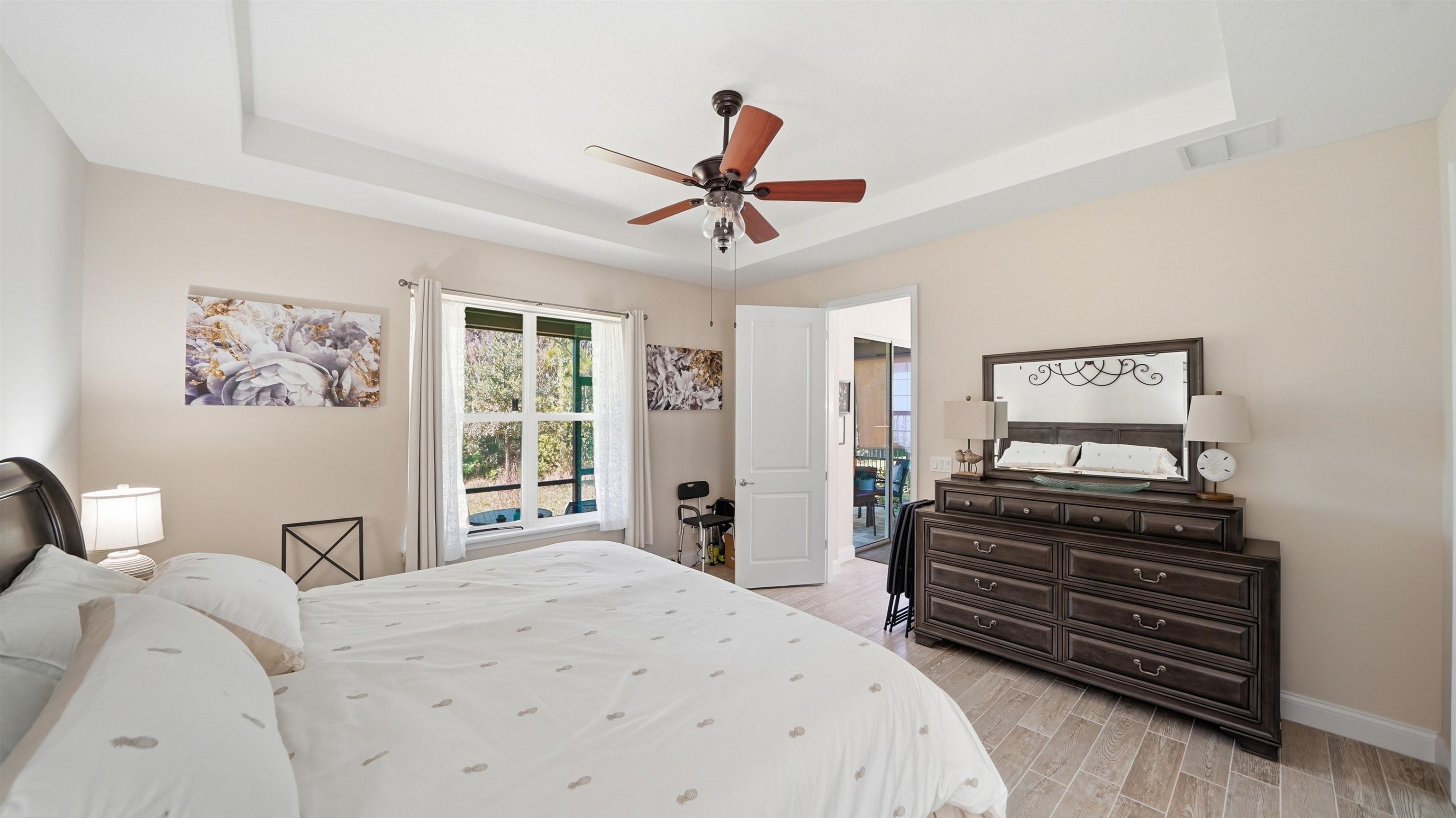 74 Wrendale Loop Ormond Beach, FL 32174 - Photo 9 of 59 Bedroom with wood finish floors, a raised ceiling, and ceiling fan
