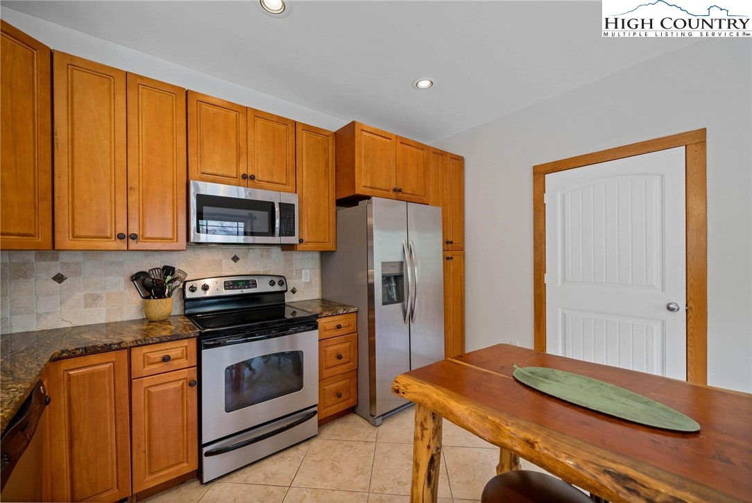 140 Spruce Hollow Road Beech Mountain, NC 28604 - Photo 14 of 50 a kitchen with stainless steel appliances granite countertop a stove refrigerator and microwave