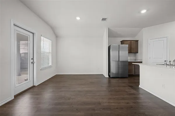 a view of a refrigerator in kitchen and wooden floor