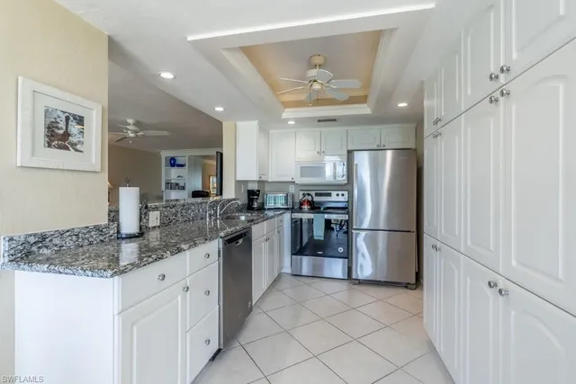 a kitchen with a refrigerator sink and cabinets