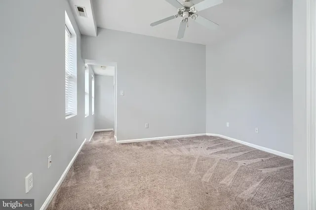 a view of an empty room with a chandelier fan
