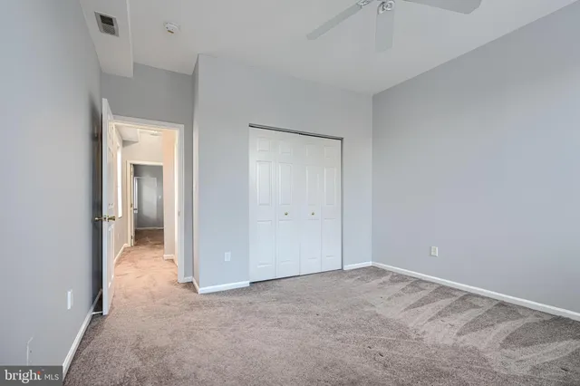 a view of an empty room with closet and a window