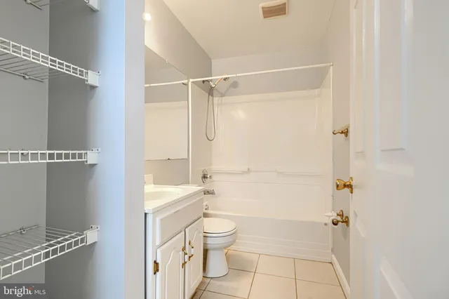 a bathroom with a granite countertop white toilet a sink and shower