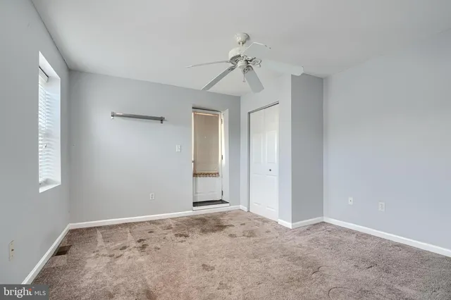 a view of a room with a chandelier fan and closet