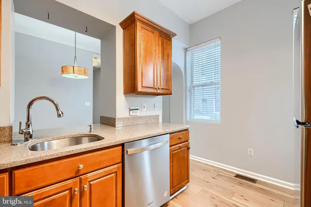 a kitchen with granite countertop stainless steel appliances a sink and a window