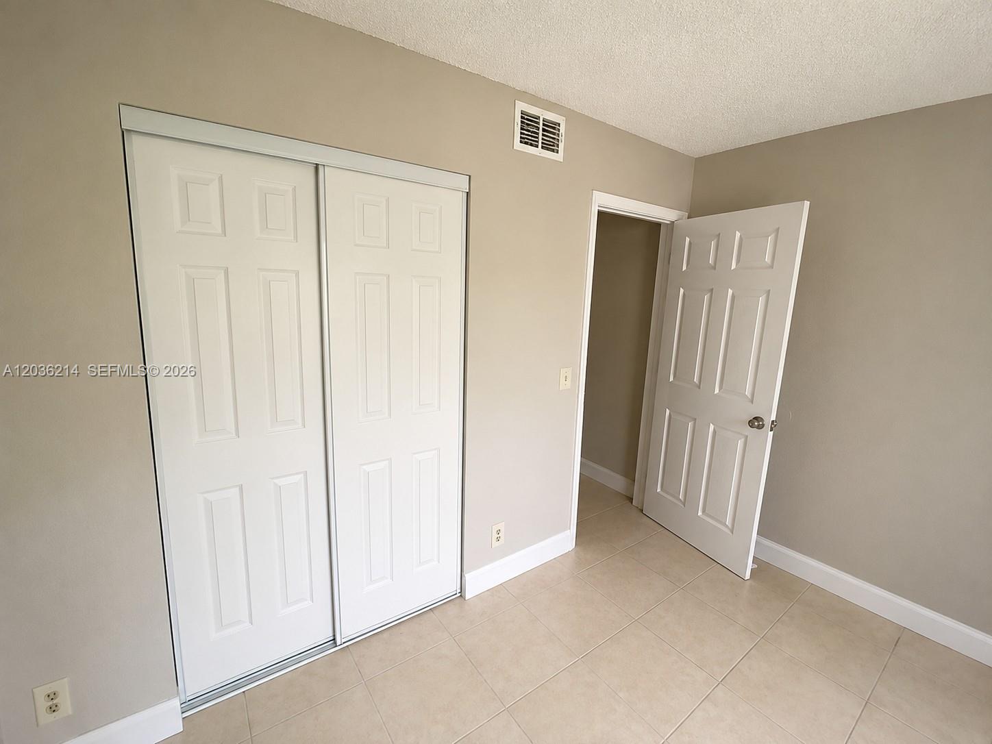 8741 Wiles Road, Unit 204 Coral Springs, FL 33067 - Photo 9 of 16 an empty room with wooden door