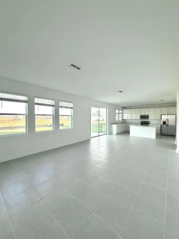 an empty room with windows and white walls